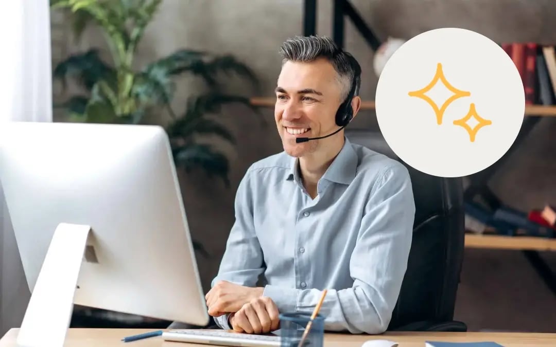 Smiling customer service agent with a headset at a computer, beside a yellow AI sparkle icon, for a post on whether agents trust AI QA scores.