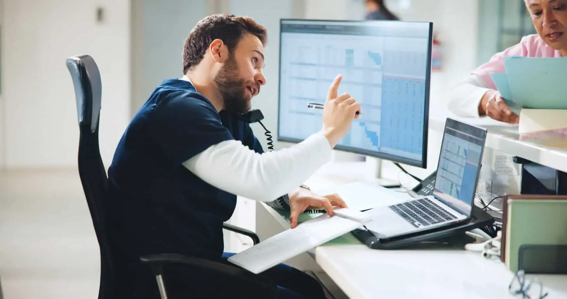 Male healthcare worker on the phone at his desk
