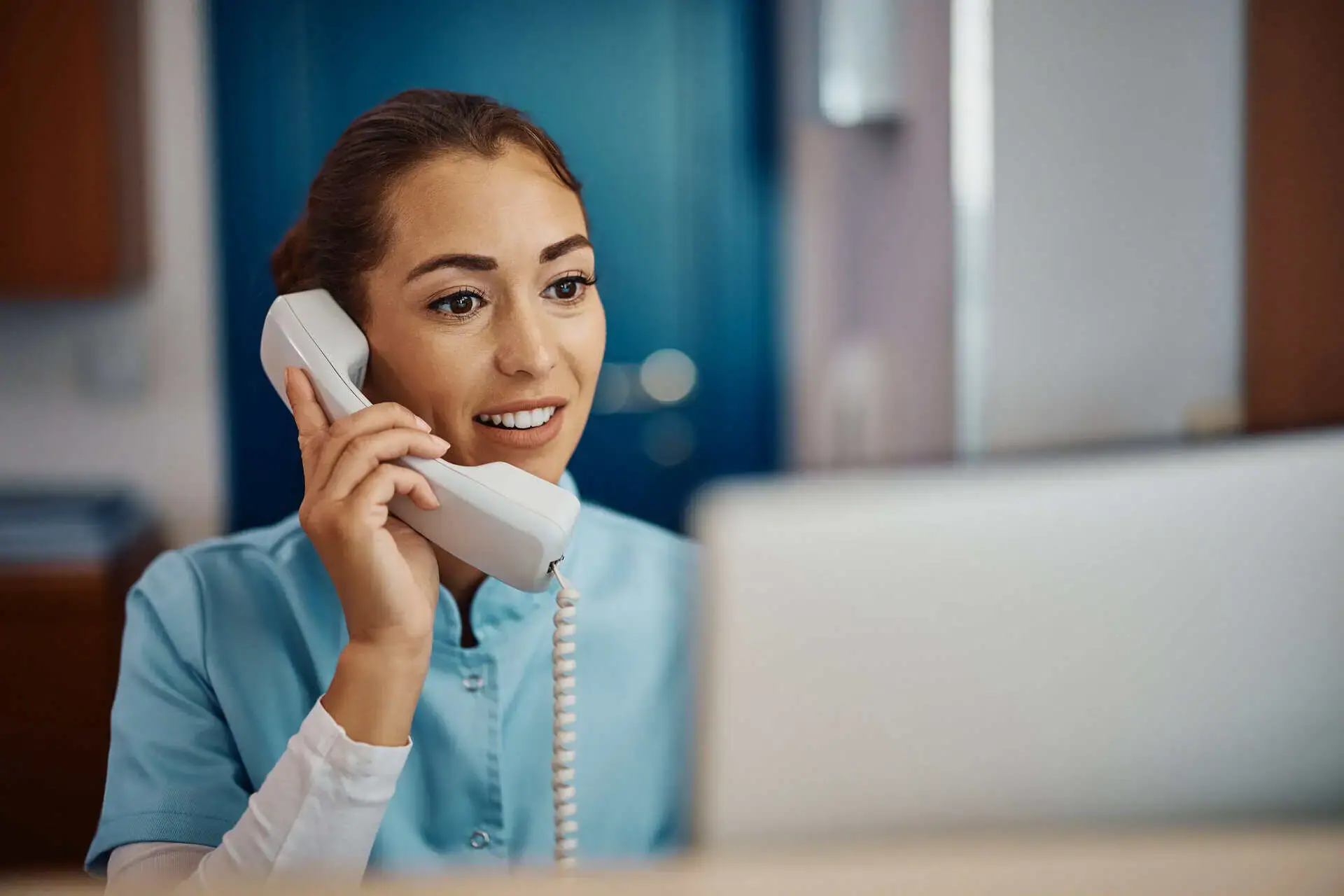 Healthcare worker on the phone at their desk