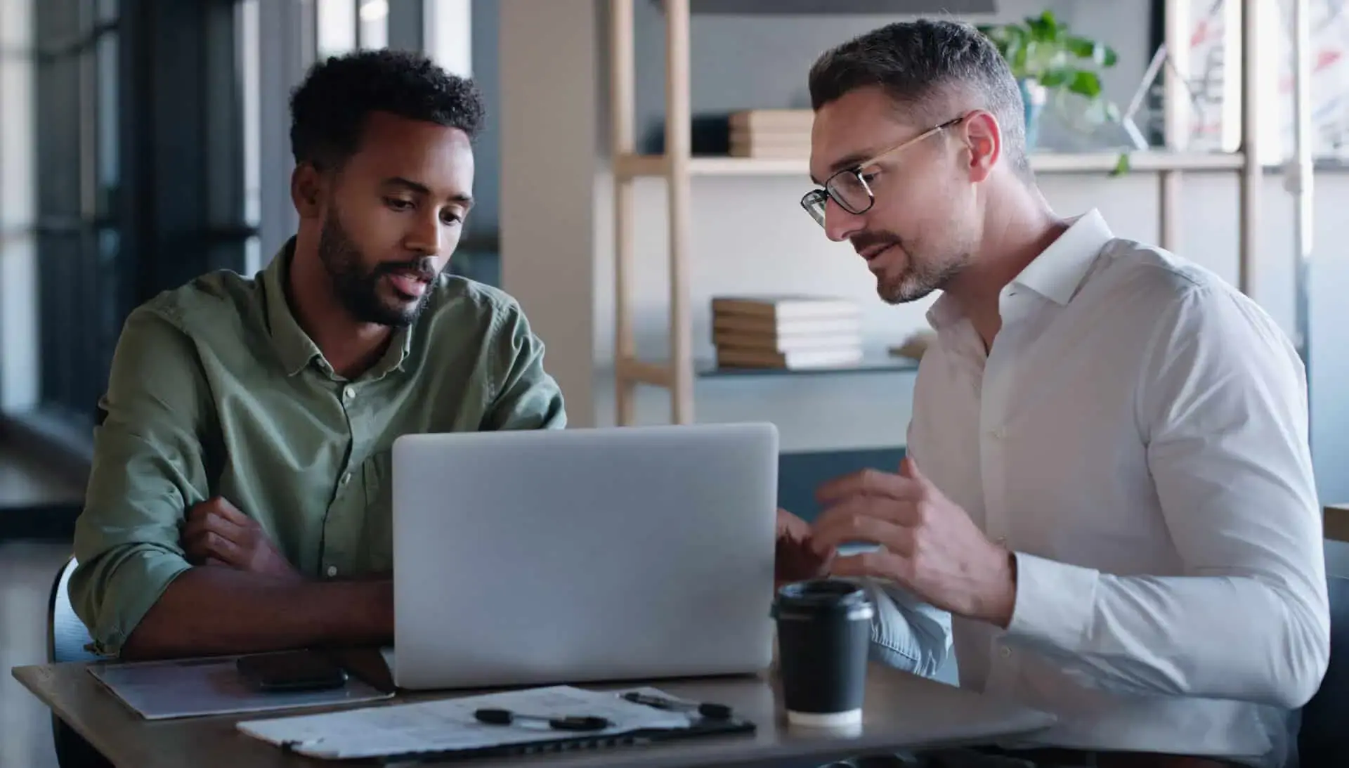 Two professionals collaborating over a laptop