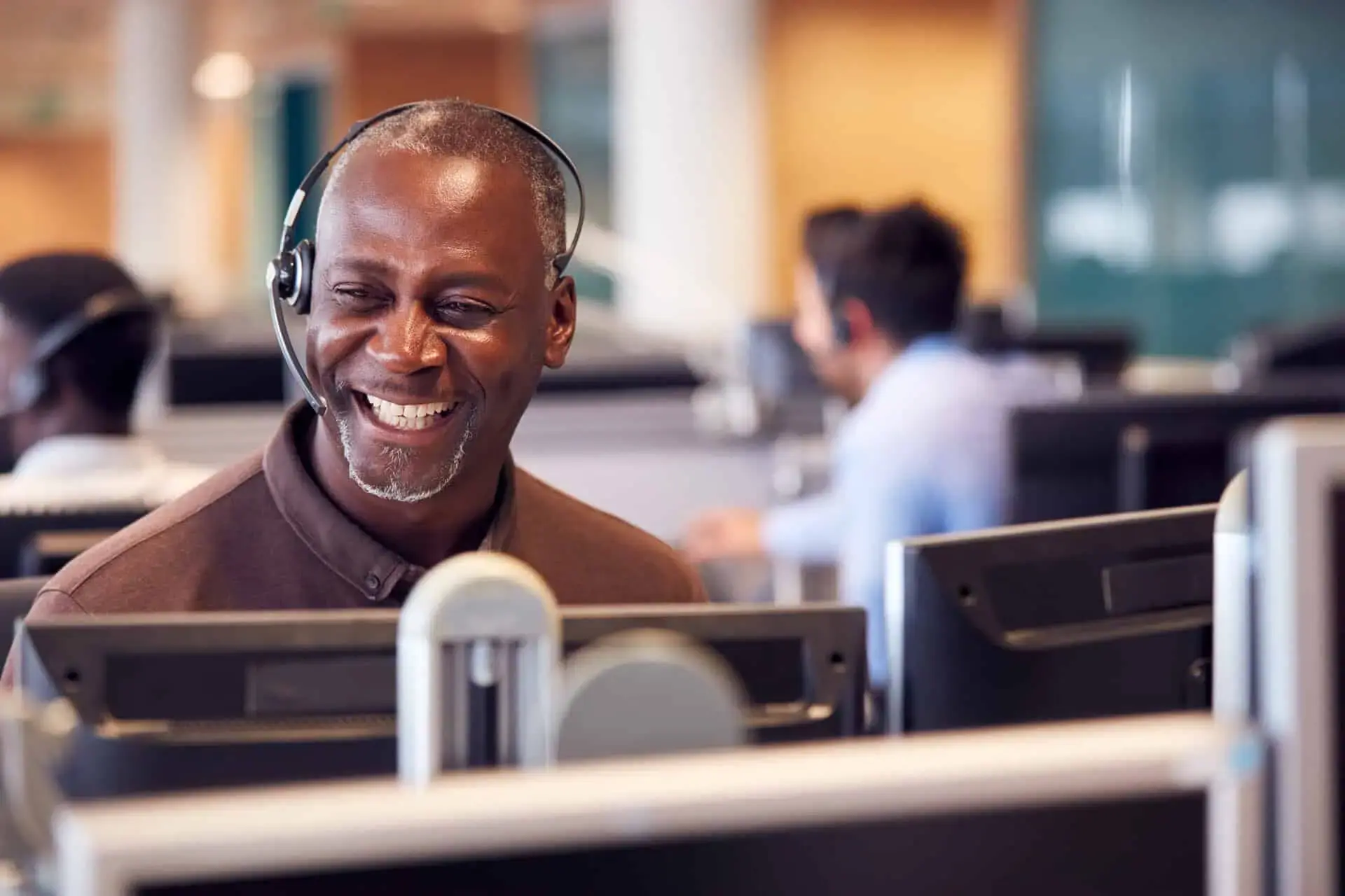 Call center agent smiling at their desk