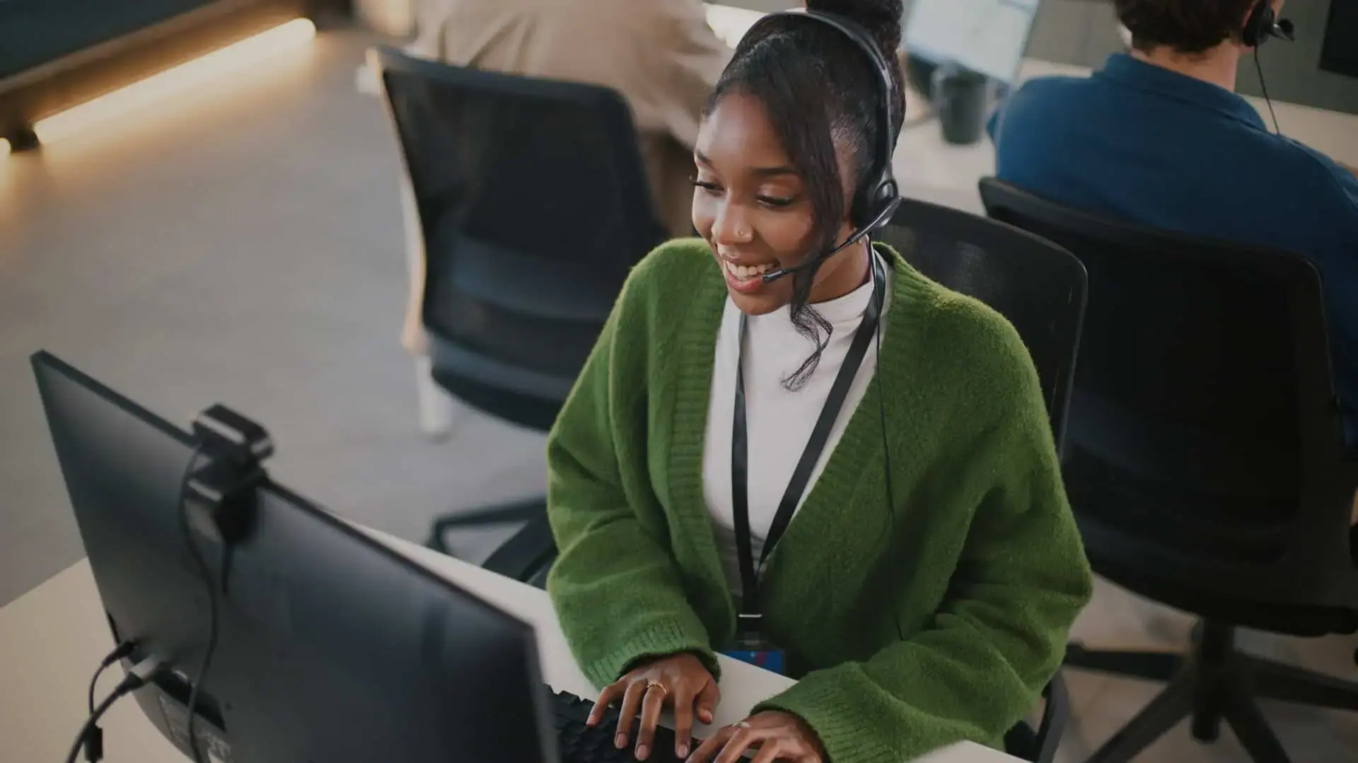 Contact center agent smiling at their computer