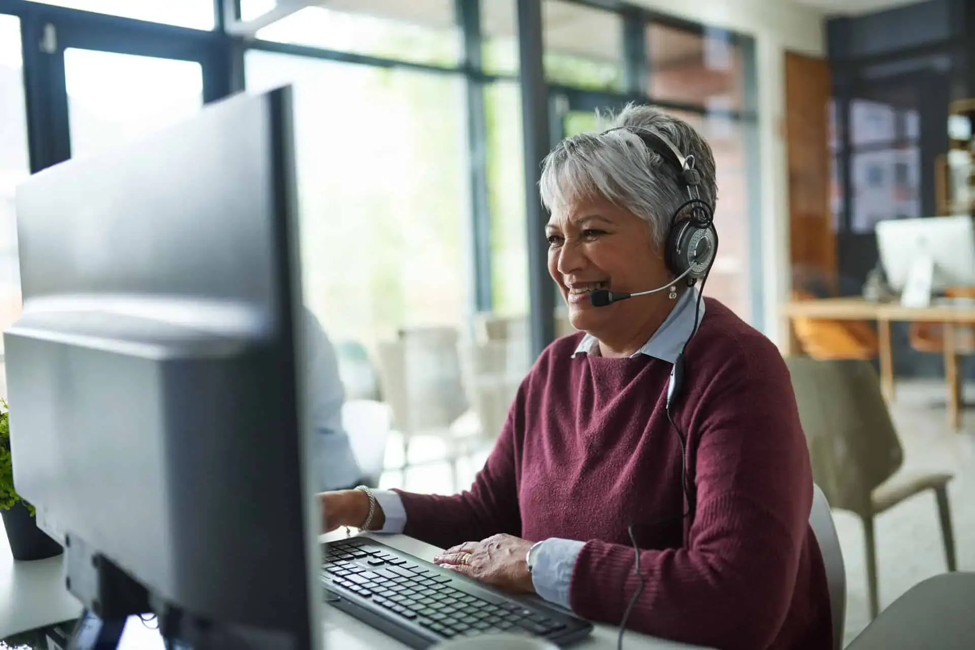 Older contact center agent working at their desk