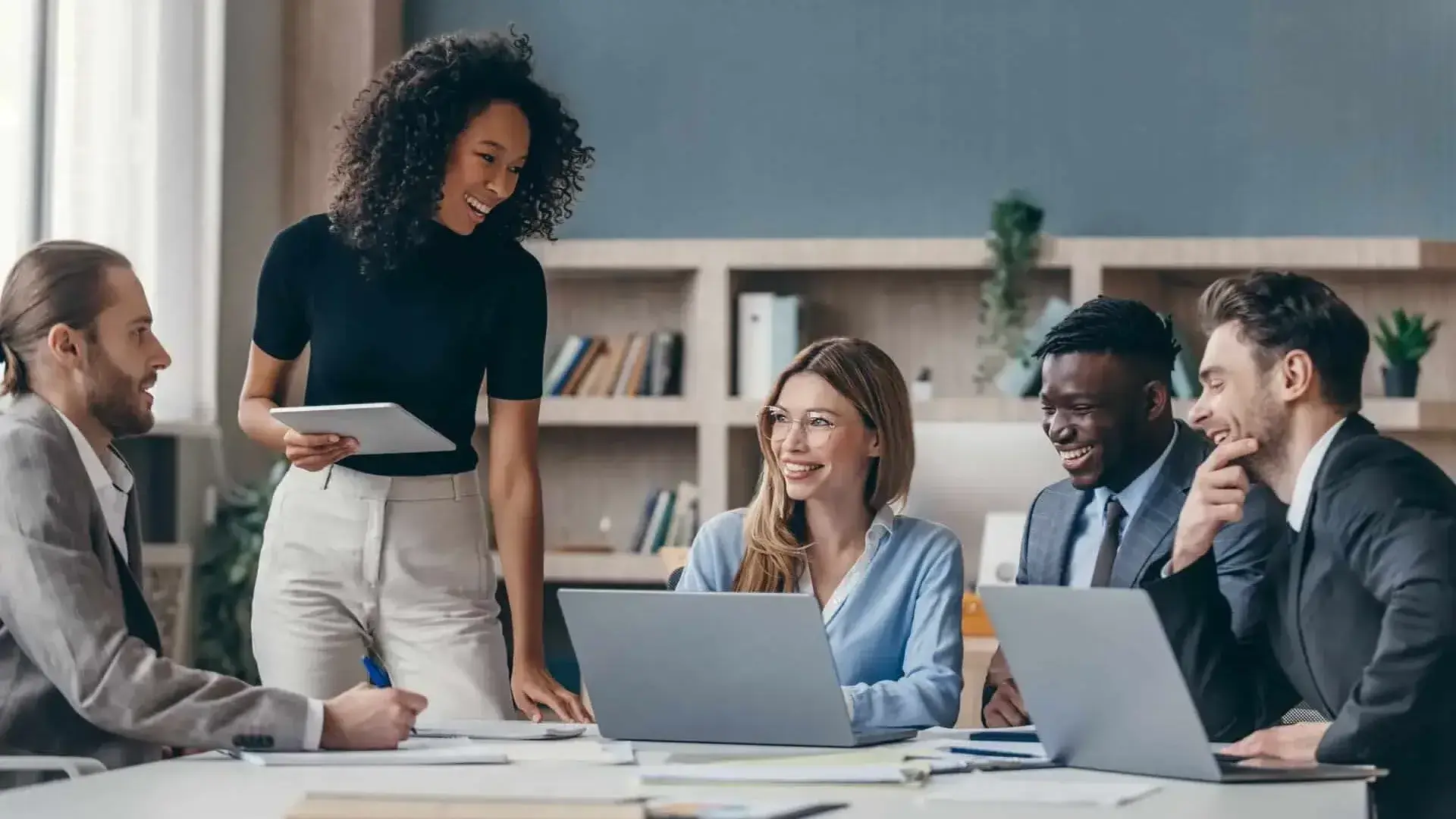 Business team smiling together with laptops at table