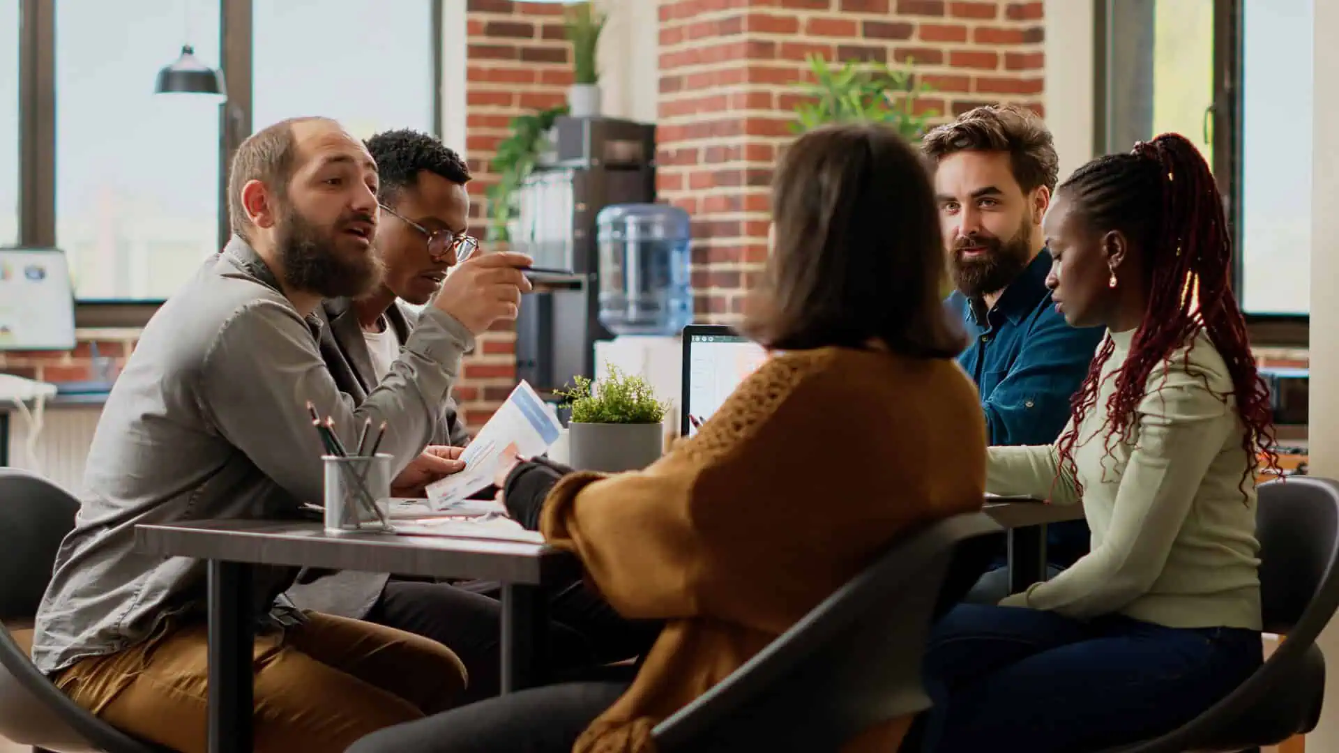 Team collaborating on a project around a laptop