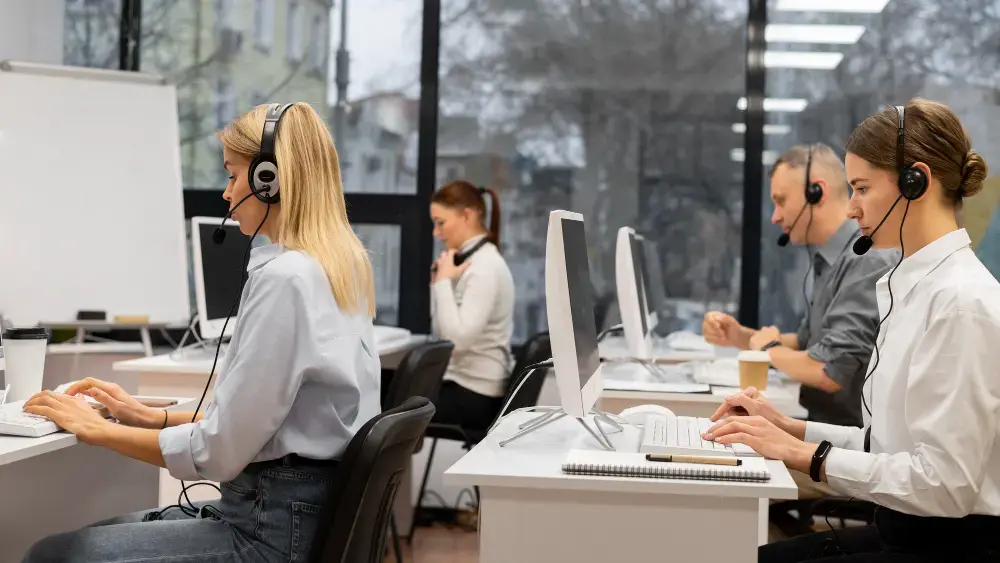 Callcenter-Agenten, die in einem modernen Büro mit Headsets und Computern arbeiten und wichtige Fähigkeiten im Bereich Kundenservice und Kommunikation unter Beweis stellen