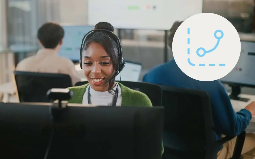 Smiling contact center agent with a headset talking to a customer at her desk, with a blue route icon linking two points, for a post on turning AI insights into agent coaching.